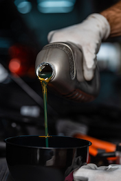 mechanic pouring oil into funnel during oil change service